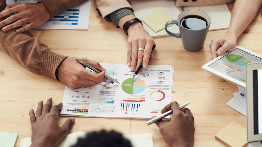Business valuation team analyzing charts and graphs on paper and tablet